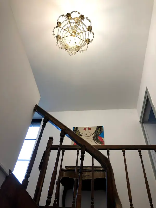 Cage d'escalier avec lustre et tableau